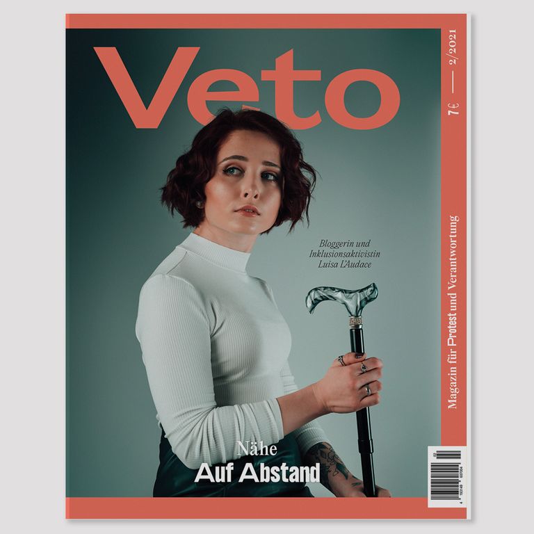 Das Cover vom Veto-Magazin auf dem Luisa abgebildet ist. Sie trägt ein weißes Turtleneck-Oberteil und in der Hand hält sie ihren Gehstock. Ihre kinnlangen roten Haare trägt sie in einem lockigen Bob und sie schaut ein wenig besorgt zur Seite. Darunter steht Nähe auf Abstand.